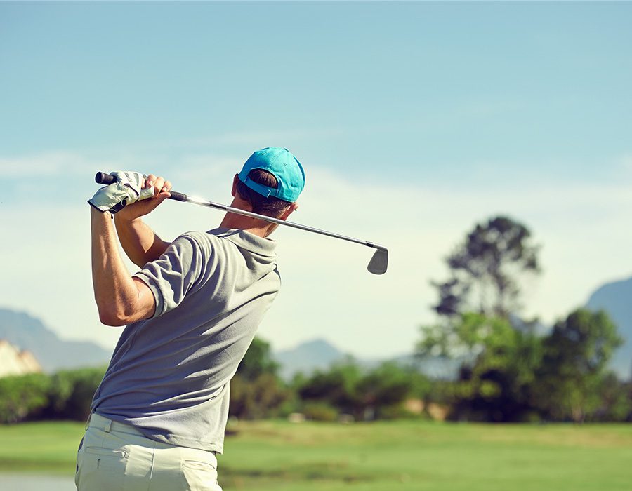 Special Events - Man Golfing on a Course and He is Swinging His Club on a Nice Day